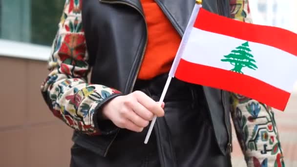 Mulher irreconhecível segurando bandeira libanesa. Menina andando rua abaixo com bandeira nacional do Líbano — Vídeo de Stock
