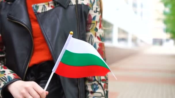 Oigenkännlig kvinna med bulgarisk flagga. Flicka promenader ner gatan med nationell flagga i Bulgarien — Stockvideo