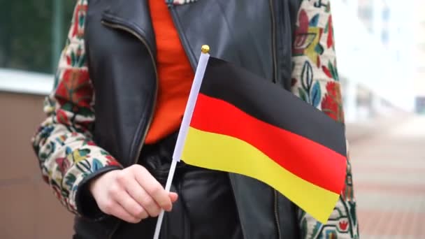 Unrecognizable woman holding German flag. Girl walking down street with national flag of Germany — Vídeo de stock