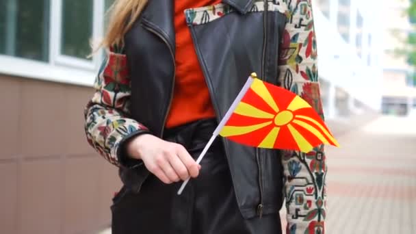 마케도니아 국기를 들고 있는 알아볼 수없는 여성. 마케도니아 국기를 들고 거리를 걷고 있는 소녀 — 비디오