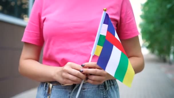 Onherkenbare vrouw met de Centraal-Afrikaanse vlag. Meisje loopt door straat met nationale vlag van Centraal-Afrikaanse Republiek — Stockvideo