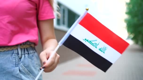 Donna irriconoscibile con bandiera irachena. Ragazza che cammina per strada con la bandiera nazionale dell'Iraq — Video Stock
