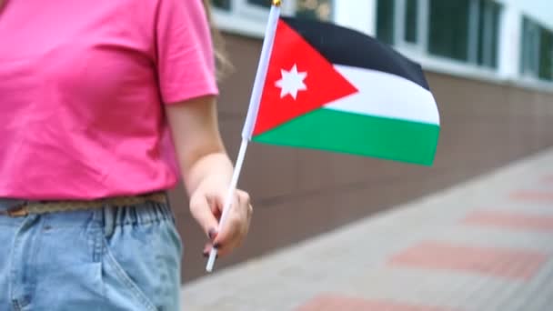 Mujer irreconocible con bandera jordana. Chica caminando por la calle con la bandera nacional de Jordania — Vídeo de stock