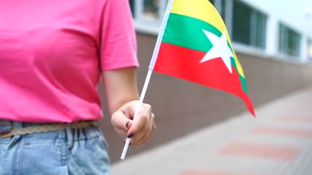 Mujer irreconocible con bandera de Myanmar. Chica caminando por la calle con la bandera nacional de Myanmar — Vídeos de Stock