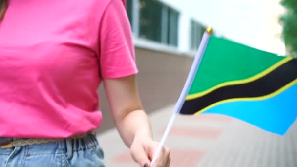 Mujer irreconocible con bandera tanzana. Chica caminando por la calle con la bandera nacional de Tanzania — Vídeos de Stock