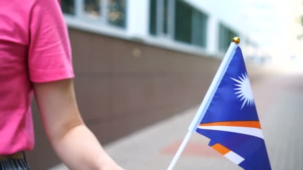 Femme méconnaissable tenant le drapeau maréchal. Fille marchant dans la rue avec le drapeau national de la République des Îles Marshall — Video