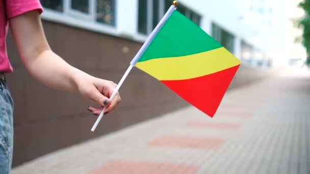 Oigenkännlig kvinna med kongolesisk flagga. Flicka går nerför gatan med Republiken Kongos flagga — Stockvideo