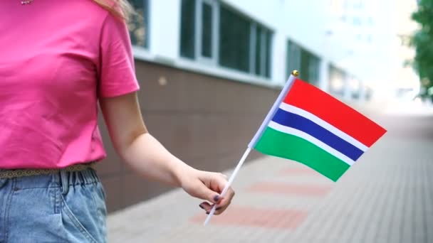 Mujer irreconocible con bandera gambiana. Chica caminando por la calle con la bandera nacional de Gambia — Vídeo de stock