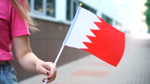 Mujer irreconocible con bandera bahreiní. Chica caminando por la calle con la bandera nacional de Bahréin — Vídeo de stock