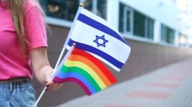 Ulusal Alman bayrağı ve Igbt gökkuşağı gay gurur bayrağını elinde tutan kadın.