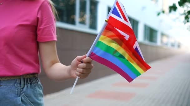 Žena drží národní britskou vlajku a lgbt duha gayská hrdost vlajka v rukou. — Stock video