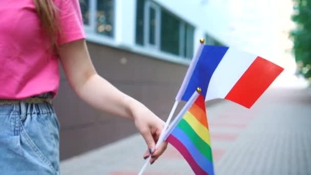 Mujer sosteniendo bandera nacional francesa y lgbt arco iris gay orgullo bandera en las manos. — Vídeo de stock