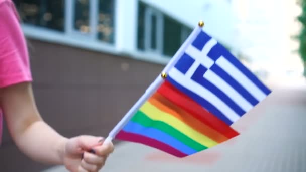Frau mit griechischer Nationalflagge und Regenbogenfahne in den Händen. — Stockvideo