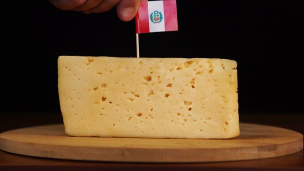 Mans hand put small in size toothpick with peruvian flag on cheese. — Stock Video