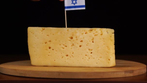 Mano Mans poner pequeño en tamaño palillo de dientes con bandera israelí en el queso. — Vídeos de Stock
