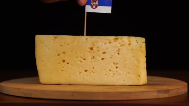 Mans hand put small in size toothpick with serbian flag on cheese. — Stock Video