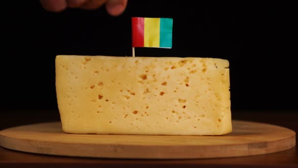 Mans hand put small in size toothpick with mali flag on cheese. — Stock Video