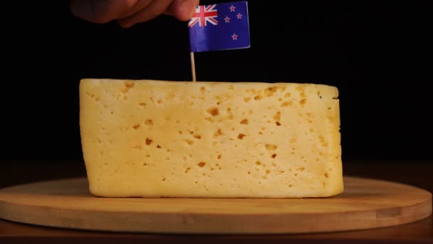 Mans mano poner pequeño en tamaño palillo de dientes con bandera de Nueva Zelanda en el queso. — Vídeo de stock