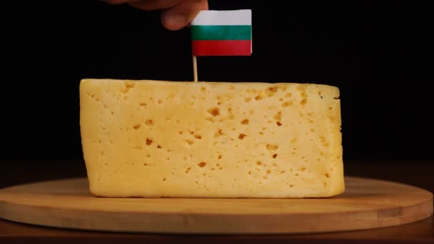 Mans mano messo piccolo stuzzicadenti dimensioni con bandiera bulgara sul formaggio. — Video Stock