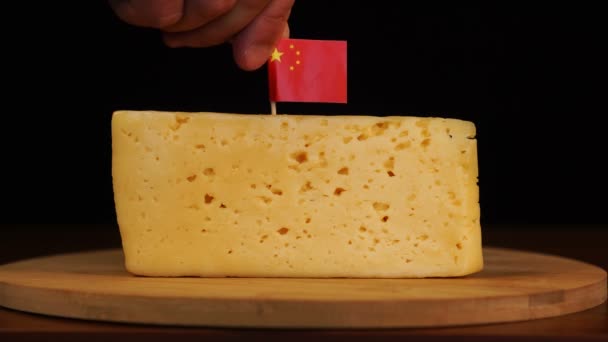 Mans hand put small in size toothpick with chinese flag on cheese. — Stock Video