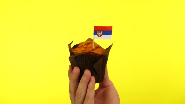 Cupcake with Serbian flag on male palm against yellow background — Stock Video