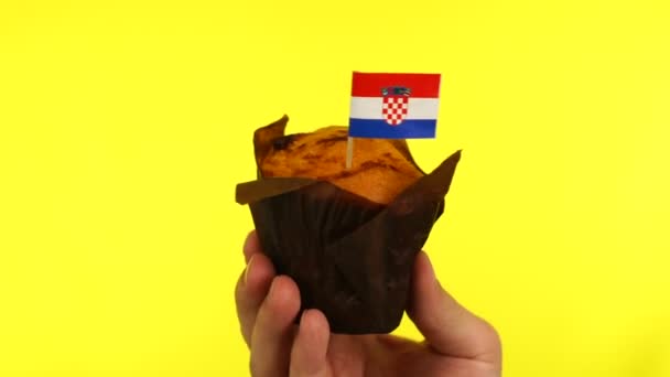 Cupcake with Croatian flag on male palm against yellow background — Stock Video