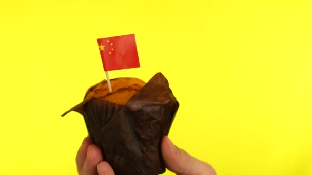 Cupcake with Chinese flag on male palm against yellow background — Stock Video