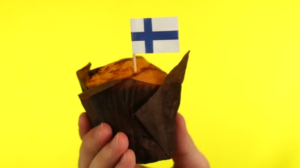 Dortík s finskou vlajkou na mužské dlani na žlutém pozadí — Stock video