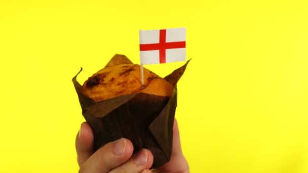 Cupcake com bandeira inglesa na palma da mão masculina contra fundo amarelo — Vídeo de Stock