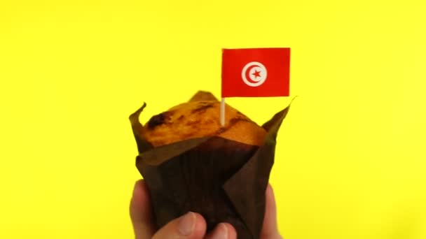 Cupcake with Tunisian flag on male palm against yellow background — Stock Video