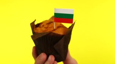 Sarı arka planda erkek avucunda Bulgar bayrağı olan kek