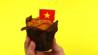 Sarı arka planda erkek avucunda Vietnam bayrağı olan kek.