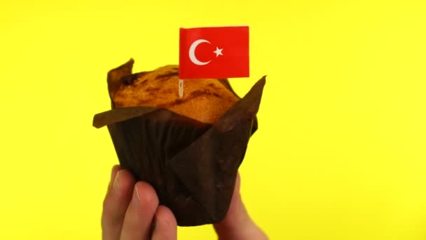Cupcake met Turkse vlag op mannelijke palm tegen gele achtergrond — Stockvideo