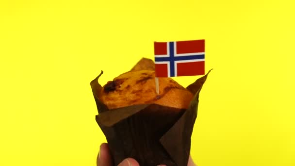 Cupcake mit norwegischer Flagge auf männlicher Palme vor gelbem Hintergrund — Stockvideo