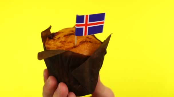 Cupcake met IJslandse vlag op mannelijke palm tegen gele achtergrond — Stockvideo