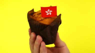 Sarı arka planda erkek avucunda Hong Kong bayrağı olan kek.