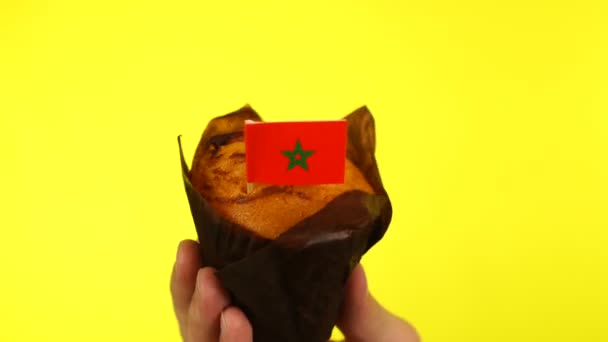Cupcake με μαροκινή σημαία στην ανδρική παλάμη σε κίτρινο φόντο — Αρχείο Βίντεο