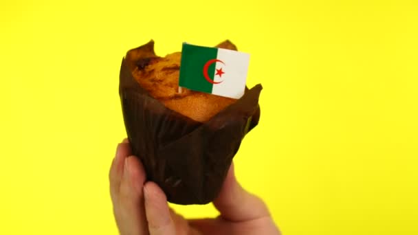 Торт з алжирським прапором на чоловічій долоні на жовтому тлі. — стокове відео