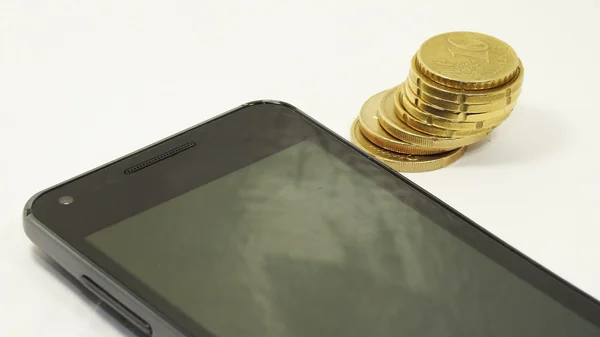 Mobile phone with coins — Stock Photo, Image