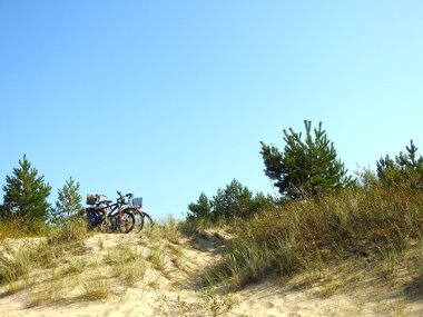 Sahilde kum bir tepe üzerinde bisiklet.