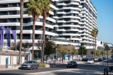 Palmiye ağaçları ve şehir trafiği olan modern şehir manzarası