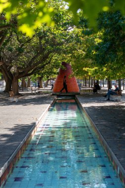 Sunny Park Sahnesi Yansıtıcı Su Özelliği ve Modern Heykel