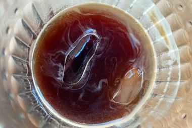 Cam bir fincanda, ahşap bir masada, yakın plan.