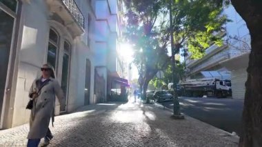 Güneşli bir bahar gününde Lizbon sokaklarını yürüyerek keşfediyor.