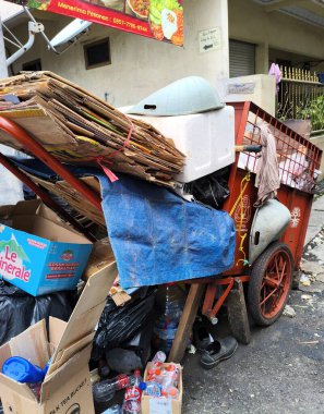 Jakarta - 17 Ekim 2025: Şehir sokaklarında çeşitli çöp ve geri dönüşümlerle dolu kırmızı bir araba