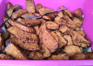 Çatallı pembe bir kapta kızarmış tempeh ve tofu 