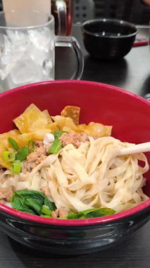 Çubuklar et ve wonton ile geniş erişteleri iştah açıcı hale getiriyor.