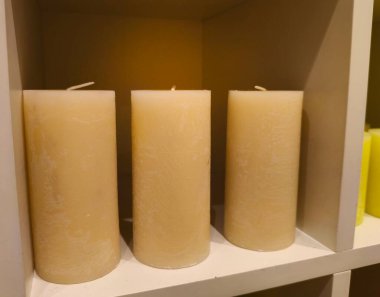 Minimalist Ev Dekorasyonu İçin Rafta Üç Beyaz Sütun Mumları