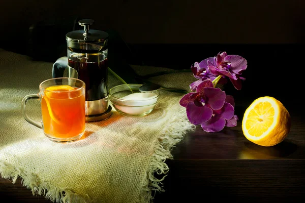 Still life tea with lemon purple orchid in dark colors — Stock Photo, Image