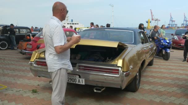 ODESSA, UCRANIA - 11 DE JUNIO DE 2016: Bike Cars y Rock n Roll festival retro. Hombre abre y cierra tronco en coche retro . — Vídeos de Stock